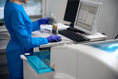 Spezialist trägt Urinproben in die Datenbank ein, die Proben werden beschriftet