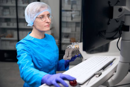 Photo for Female laboratory assistant works with a database of working data, modern equipment in the laboratory - Royalty Free Image