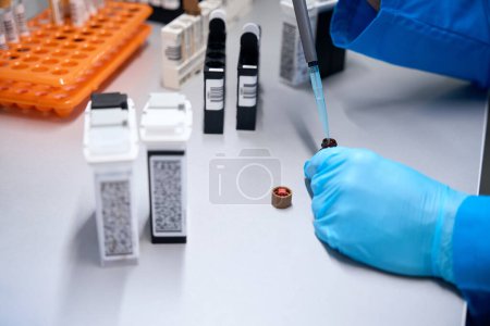 Téléchargez les photos : Spécialiste travaille avec des échantillons de sang dans les éprouvettes, à l'aide d'un distributeur de pipettes de laboratoire - en image libre de droit