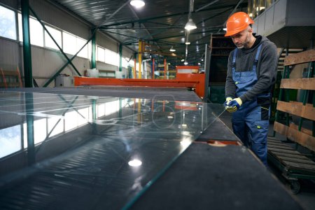 Photo for Worker cuts glass for a double-glazed window, modern high-tech equipment is used in production - Royalty Free Image