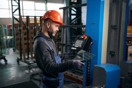 Photo for Employee holds in his hands drilled glass for a double-glazed window, modern high-tech equipment is used in production - Royalty Free Image