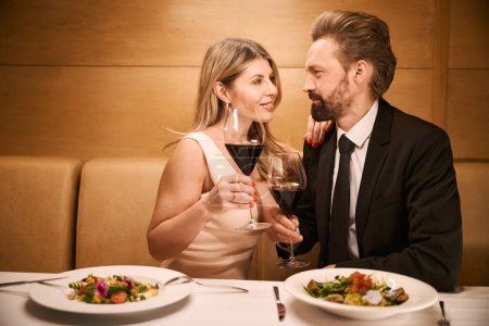 Foto de Señora de mediana edad y su compañero están hablando durante una cena romántica en un restaurante, la dama tiene un escote profundo - Imagen libre de derechos