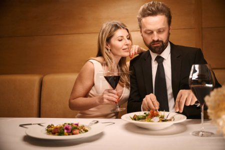 Foto de Feliz dama y su compañero están hablando durante una cena romántica en un restaurante, la dama tiene un escote profundo - Imagen libre de derechos