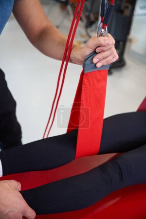 Spezialist verwendet Rotschnur in Rehabilitationsprogramm für Klienten, ein Hängeschlaufensystem wird verwendet