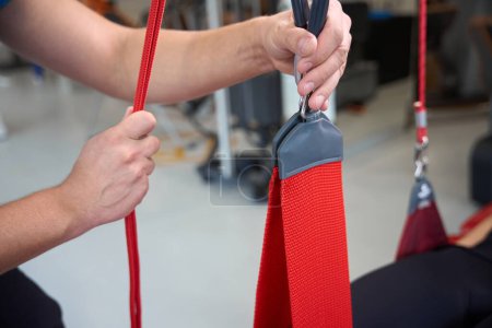 Photo for Rehabilitation therapist works with a female patient on redcord, using modern equipment - Royalty Free Image