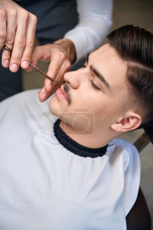 Téléchargez les photos : Hipster client visitant salon de coiffure pour coiffer sa moustache - en image libre de droit
