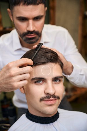 Foto de Hombre guapo con bigote conseguir nuevo peinado en la barbería - Imagen libre de derechos