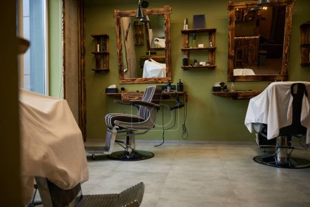 Téléchargez les photos : Lieu de travail vide de salon de coiffure avec chaise d'équipement et miroir - en image libre de droit