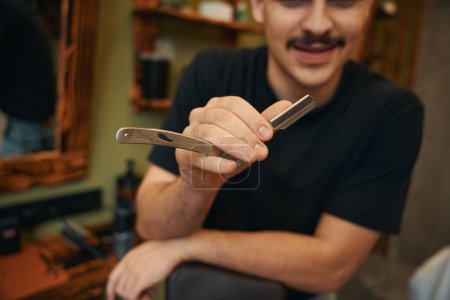 Téléchargez les photos : Homme inconnu coiffeur avec rasoir dans les mains dans le salon de coiffure - en image libre de droit
