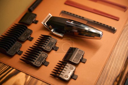 Téléchargez les photos : Tondeuse électrique avec lames de rasoir propres sur la table dans le salon de coiffure - en image libre de droit