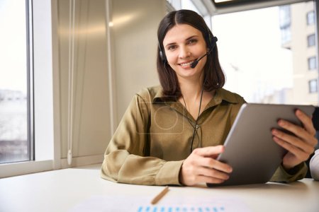 Téléchargez les photos : Femme confiante appelant parler à des clients cellulaire produits en ligne assis à son lieu de travail - en image libre de droit