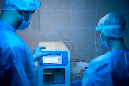 Equipo de virólogos trabaja en equipos modernos para estudiar biomaterial, la esterilidad se mantiene en el laboratorio