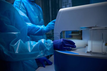 Los especialistas en virología usan equipos especiales para estudiar biomateriales, las personas trabajan con guantes protectores