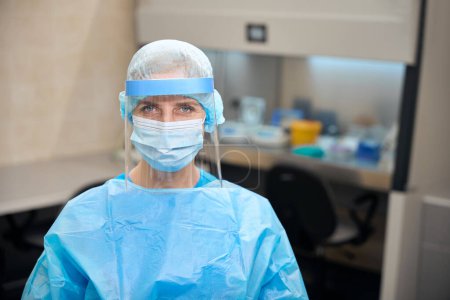 Female infectious disease specialist in laboratory in protective equipment, sterile room