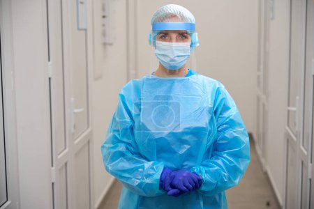Téléchargez les photos : Spécialiste des maladies infectieuses dans un laboratoire moderne en équipement de protection, elle utilise un bouclier de protection - en image libre de droit