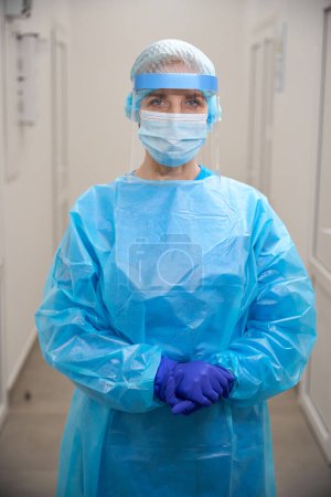 Photo for Female healthcare worker in a modern laboratory in protective equipment, she uses a protective shield - Royalty Free Image