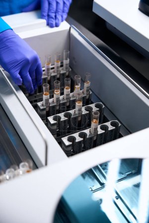 Asistente de laboratorio femenino trabaja con muestras biomateriales en el laboratorio, se utilizan tubos especiales de laboratorio