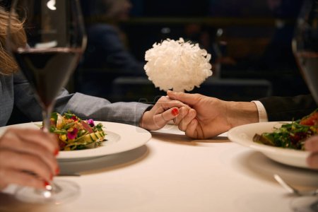 Téléchargez les photos : Couple dînant dans un restaurant confortable, vin rouge commandé - en image libre de droit