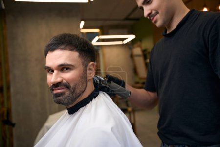 Foto de Peluquería hombre haciendo corte de pelo para el cliente en la barbería - Imagen libre de derechos
