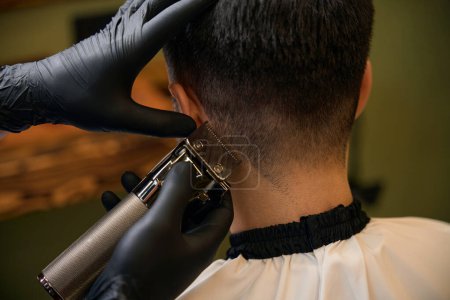 Téléchargez les photos : Maître coiffeur faire des soins et un nouveau look de coiffure pour le client masculin au salon de coiffure - en image libre de droit