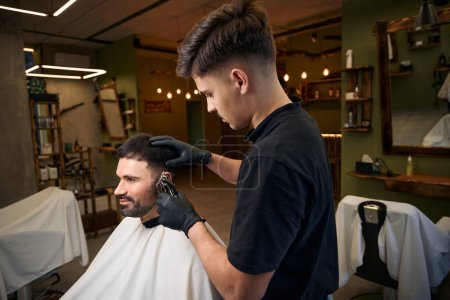 Téléchargez les photos : Bel homme barbu obtenir nouvelle coiffure au salon de coiffure - en image libre de droit