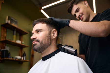 Foto de Hombre barbudo guapo conseguir nuevo peinado en la barbería - Imagen libre de derechos