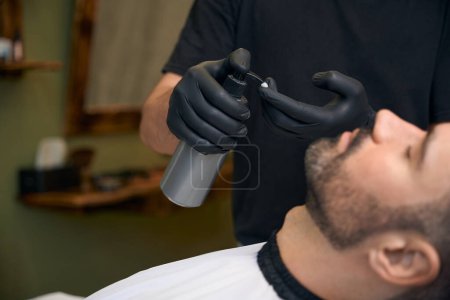 Photo for Barber master doing beard styling for customer in barbershop - Royalty Free Image