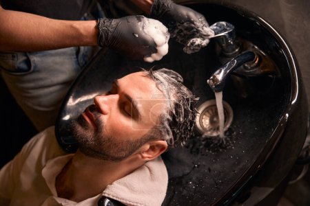 Foto de Cliente disfrutando del procedimiento de lavado de cabello en la barbería - Imagen libre de derechos