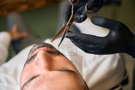 Téléchargez les photos : Style barbe et coupe avec ciseaux pour homme client au salon de coiffure - en image libre de droit