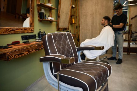 Téléchargez les photos : Coiffeur servant client à l'espace de travail salon de coiffure - en image libre de droit