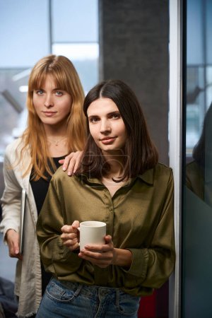 Téléchargez les photos : Deux créatrices de vêtements confiantes ayant pause posant au bureau - en image libre de droit