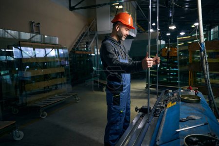 Photo for Man works in a window production, he is carrying out the initial sealing of the spacer frame - Royalty Free Image