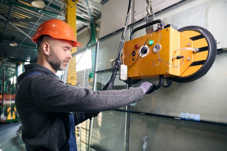 Foreman utiliza equipos modernos en un taller de producción, un hombre con un casco de seguridad