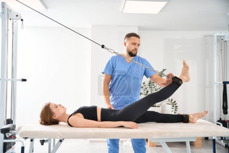 Photo for Effective procedure for spinal traction on a special simulator, an experienced specialist works with the patient - Royalty Free Image