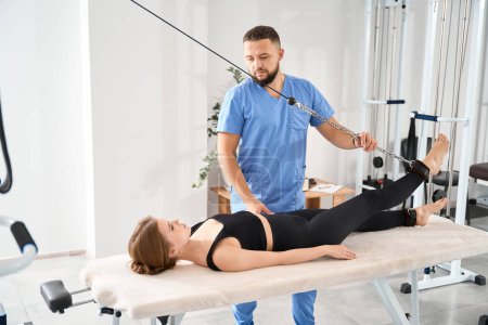 Téléchargez les photos : Procédure de traction vertébrale sur un simulateur spécial, le patient repose sur une table de massage - en image libre de droit