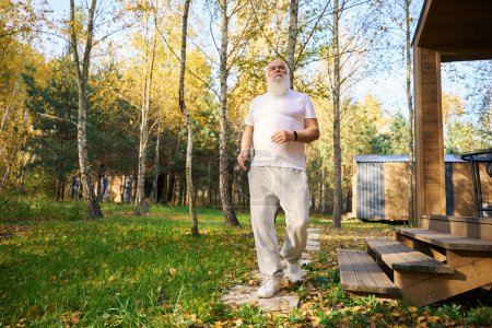 Téléchargez les photos : Le vieil homme a quitté la maison pour un jogging matinal, il portait des vêtements légers confortables - en image libre de droit