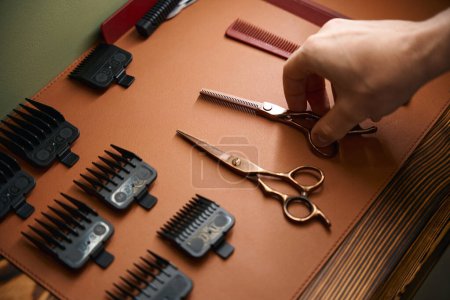 Téléchargez les photos : Cisailles de coiffure dans les mains d'un coiffeur non identifié dans le salon de coiffure - en image libre de droit