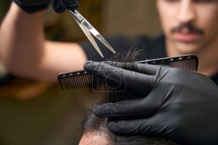 Photo for Professional barber cutting hair making hairdo in barbershop - Royalty Free Image
