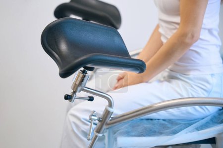 Photo for Client visiting gynecologist, sitting on special chair and waiting for doctor in hospital - Royalty Free Image