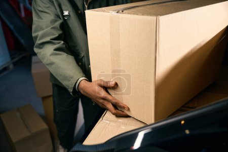 Amerikanischer Mann zerlegt Schachteln mit Dingen aus einer Maschine. Nahaufnahme