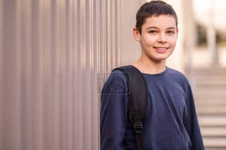 Photo for Waist-up portrait of a cute dark-haired teenage boy with a happy smile looking ahead - Royalty Free Image