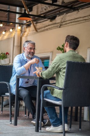 Photo for Two friends. Two men sitting in the cafe and having an interesting conversation - Royalty Free Image
