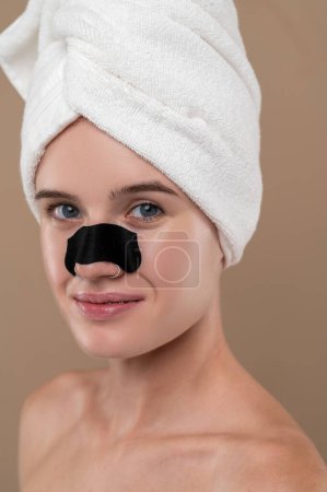 Foto de Procedimientos de belleza. Primer plano de una chica con una franja nasal limpiadora - Imagen libre de derechos