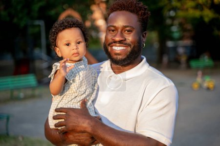 Photo for Waist-up portrait of a happy young father holding his cute little daughter in his arms - Royalty Free Image