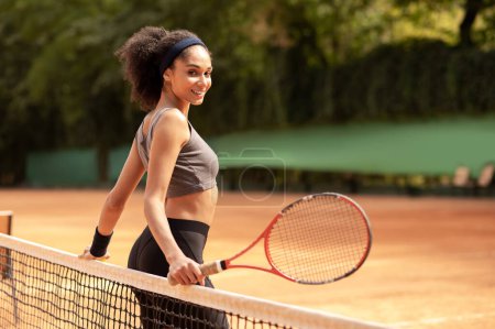 Foto de Me encanta el tenis. Linda chica morena haciendo ejercicio en la cancha de tenis - Imagen libre de derechos