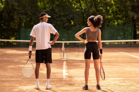 Foto de Entrenamiento. Dos jóvenes haciendo ejercicio en la cancha de tenis - Imagen libre de derechos
