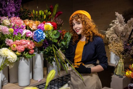Téléchargez les photos : Au travail. Fleuriste travaillant avec les fleurs dans un magasin de fleurs - en image libre de droit
