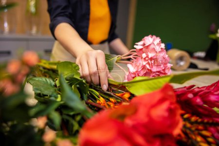 Foto de En el trabajo. Floristería trabajando con las flores en una floristería - Imagen libre de derechos
