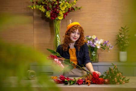 Téléchargez les photos : Fleuriste au travail. Fleuriste choisissant des fleurs pour bouquets dans un magasin de fleurs - en image libre de droit