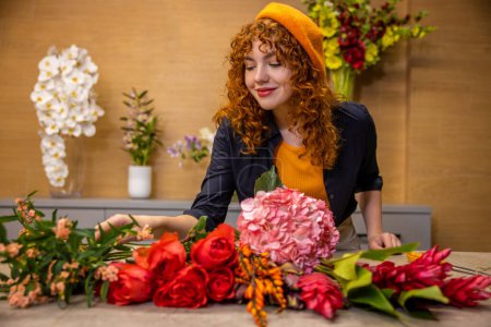 Foto de Florista en el trabajo. Floristería que elige flores para ramos en una tienda de flores - Imagen libre de derechos